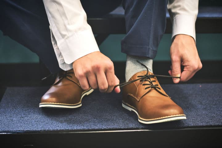 close up of man tying dress shoe